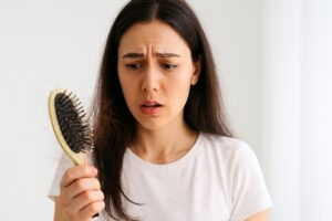 Causes of hair fall shown by hair on brush
